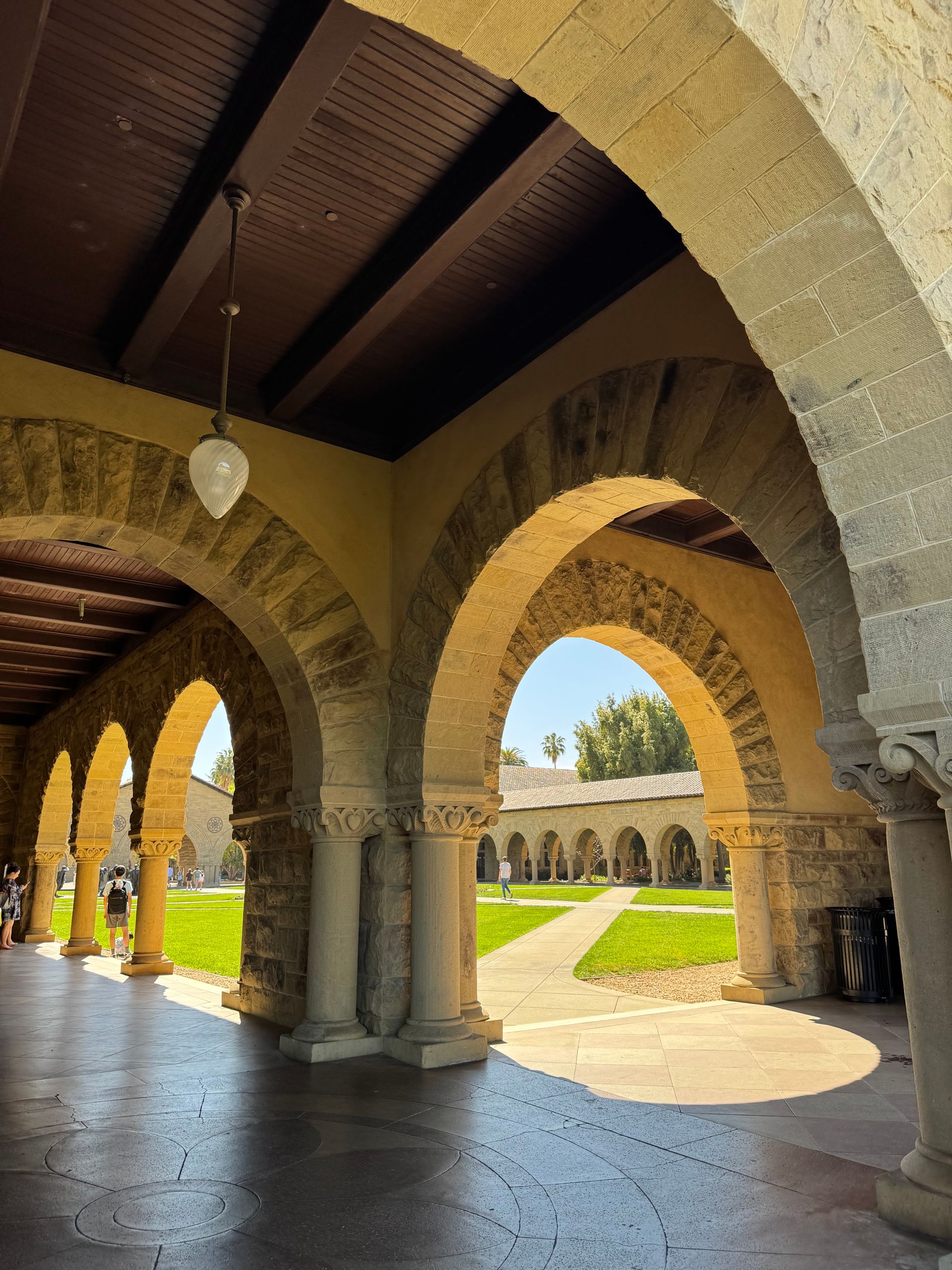 Historic stone archways with a sunny courtyard at Stanford University, California.